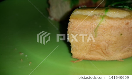 Close up shot of the texture of homemade sponge cake filling on a green tray. Close up shot of the texture of homemade sponge cake filling on a green tray. 141640609