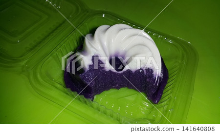 White and purple cake with a smooth texture, already partially eaten. White and purple cake with a smooth texture, already partially eaten. 141640808