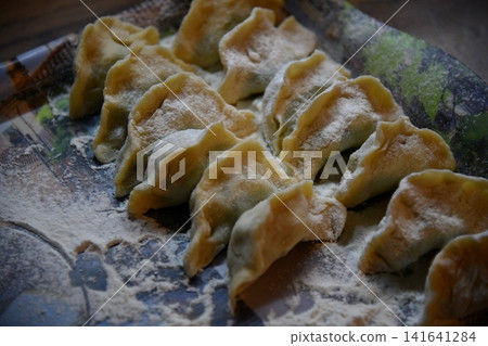 Dumplings, filled with cabbage. Varenyky, vareniki, pierogi, pyrohy - dumplings with filling. View from above, top studio shot Dumplings, filled with cabbage. Varenyky, vareniki, pierogi, pyrohy - dumplings with filling. View from above, top studio shot 141641284