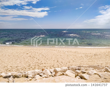 Serene coastal beach scene with nobody. Golden sand meets the calm turquoise ocean under a bright blue sky, evoking feelings of peaceful escape, summer vacation, and tranquility. Serene coastal beach scene with nobody. Golden sand meets the calm turquoise ocean under a bright blue sky, evoking feelings of peaceful escape, summer vacation, and tranquility. 141641737