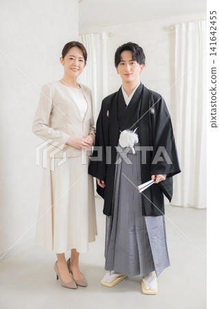 一位身著正式和服和袴的年輕男子和他的母親。 一位身著正式和服和袴的年輕男子和他的母親。 141642455