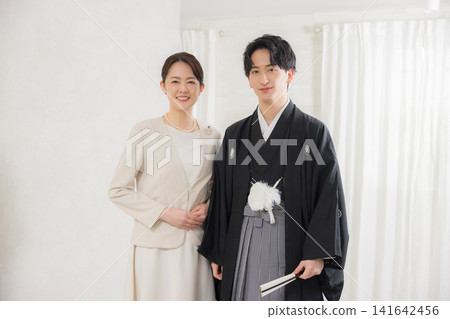 一位身著正式和服和袴的年輕男子和他的母親。 一位身著正式和服和袴的年輕男子和他的母親。 141642456