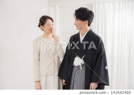 A young man in formal kimono and hakama and his mother. A young man in formal kimono and hakama and his mother. 141642460