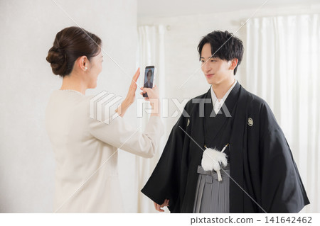 A young man in formal kimono and hakama and his mother. A young man in formal kimono and hakama and his mother. 141642462
