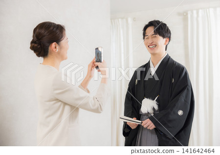 A young man in formal kimono and hakama and his mother. A young man in formal kimono and hakama and his mother. 141642464