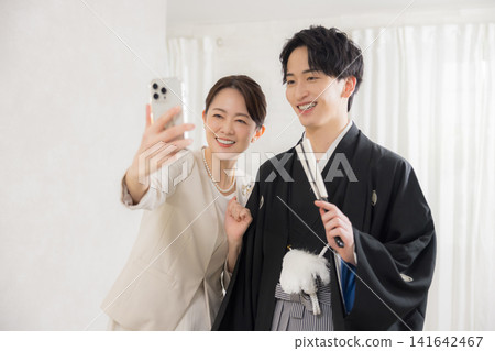 一位身著正式和服和袴的年輕男子和他的母親。 一位身著正式和服和袴的年輕男子和他的母親。 141642467