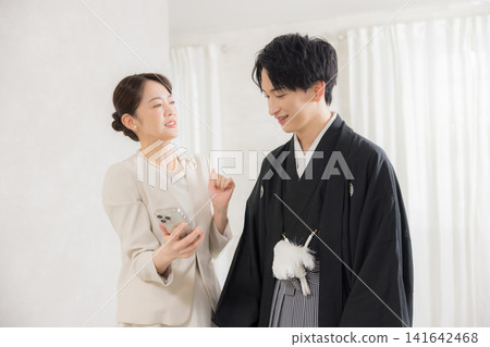 一位身著正式和服和袴的年輕男子和他的母親。 一位身著正式和服和袴的年輕男子和他的母親。 141642468