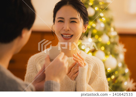 A young couple exchanging Christmas presents A young couple exchanging Christmas presents 141642533