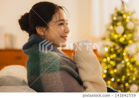 Woman relaxing in the living room at night Woman relaxing in the living room at night 141642559