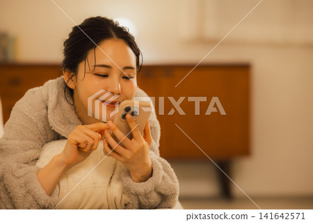 Woman relaxing in the living room at night 141642571