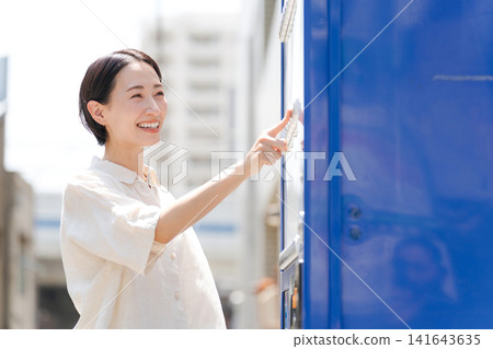 A woman buying a drink from a vending machine. A woman buying a drink from a vending machine. 141643635