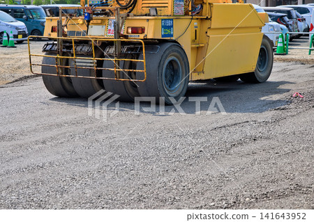Parking lot construction: Ground compaction work using a road roller. Parking lot construction: Ground compaction work using a road roller. 141643952