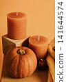 Candles and pumpkins on wooden shelves on yellow background 141644574