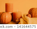 Candles, pumpkins and sweater on yellow background, close up 141644575