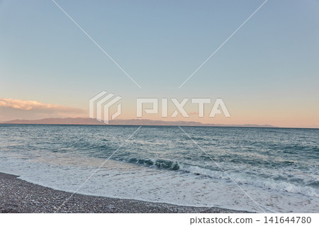 黃昏,海浪拍打著鵝卵石海灘 黃昏,海浪拍打著鵝卵石海灘 141644780