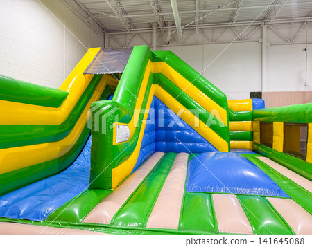 Inflatable bounce house located indoors at a playground Inflatable bounce house located indoors at a playground 141645088