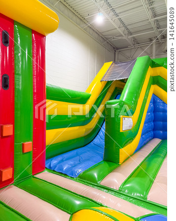 Inflatable bounce house located indoors at a playground Inflatable bounce house located indoors at a playground 141645089