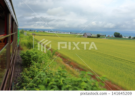 A view of the cloudy Daisetsuzan mountain range from the 50 series passenger cars of the Furano-Biei Norokko train. A view of the cloudy Daisetsuzan mountain range from the 50 series passenger cars of the Furano-Biei Norokko train. 141645209