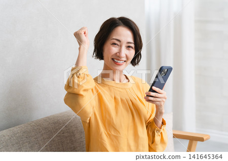 Woman operating a smartphone Lifestyle image Woman operating a smartphone Lifestyle image 141645364