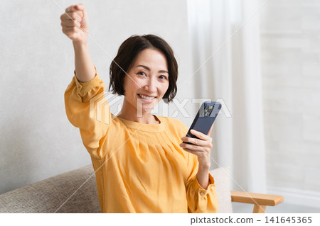 Woman operating a smartphone Lifestyle image Woman operating a smartphone Lifestyle image 141645365