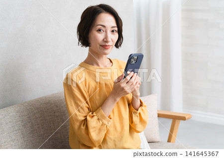 Woman operating a smartphone Lifestyle image Woman operating a smartphone Lifestyle image 141645367