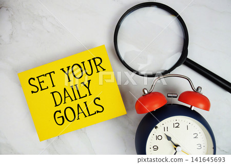Set Your Daily Goals text with sticky note and alarm clock flat lay on marble background Set Your Daily Goals text with sticky note and alarm clock flat lay on marble background 141645693