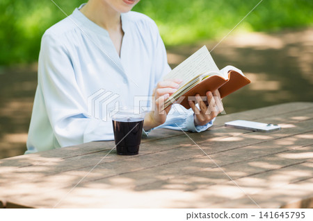 戶外閱讀的年輕女子生活方式形象 戶外閱讀的年輕女子生活方式形象 141645795