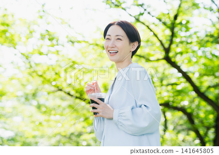 Young woman drinking iced coffee lifestyle image Young woman drinking iced coffee lifestyle image 141645805