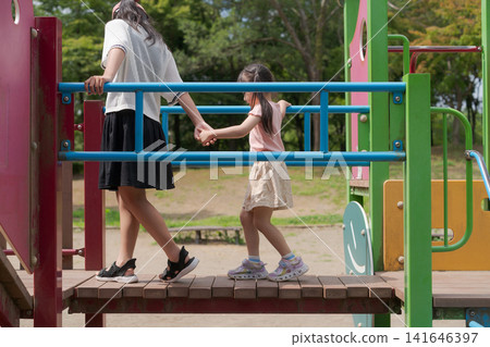 Sisters playing with playground equipment Sisters playing with playground equipment 141646397