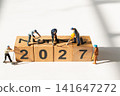Miniature Construction Workers Building 2027 with Wooden Number Blocks New Year Concept 141647272