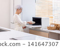 Meals: Senior women warming up their packed lunches at home. 141647307