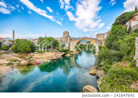 Amazing Skyline of Mostar with the Mostar Bridge, houses and minarets, during sunny day Amazing Skyline of Mostar with the Mostar Bridge, houses and minarets, during sunny day 141647691