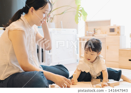 Parent and child playing in a room / Child-rearing image / Girl playing with building blocks 141647943