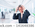 A middle-aged businessman with his head in his hands in the office 141648386
