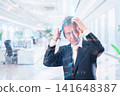 A middle-aged businessman with his head in his hands in the office 141648387