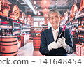 A middle-aged male sommelier holding a bottle of wine 141648454