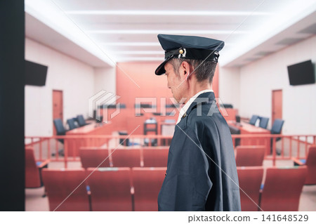 A middle-aged man working as a prison guard at a courthouse. A middle-aged man working as a prison guard at a courthouse. 141648529