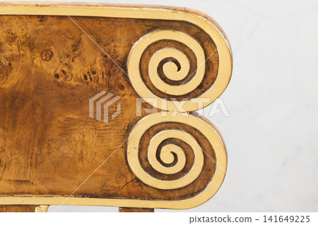 Gilded wooden furniture detail showing a double spiral scroll motif Gilded wooden furniture detail showing a double spiral scroll motif 141649225