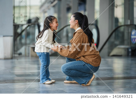 excited child girl laughing with her mother in shopping mall or department store excited child girl laughing with her mother in shopping mall or department store 141649321