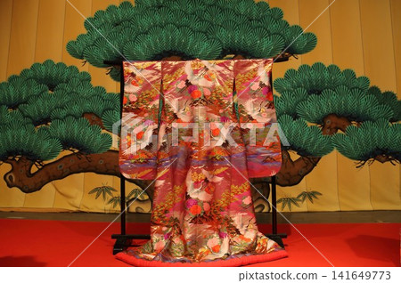 一件華麗的打褂(婚禮和服)在松樹的襯托下顯得格外美麗。 一件華麗的打褂(婚禮和服)在松樹的襯托下顯得格外美麗。 141649773