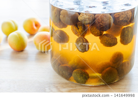 Aged plum syrup and harvested ripe plums Aged plum syrup and harvested ripe plums 141649998