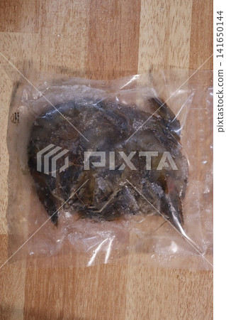 Frozen Seafood in Plastic Bag on Wooden Surface Frozen Seafood in Plastic Bag on Wooden Surface 141650144