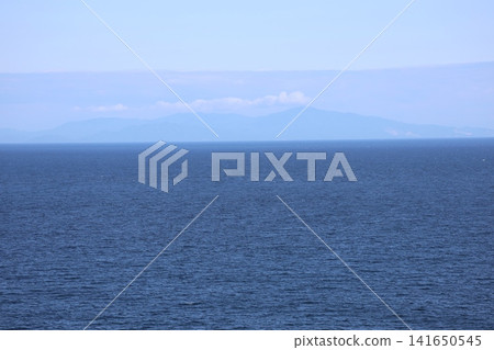 蔚藍的海洋、朦朧的島嶼和天空所構成的景色。 蔚藍的海洋、朦朧的島嶼和天空所構成的景色。 141650545