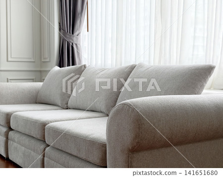 Close-up of comfortable beige fabric couch in living room corner Close-up of comfortable beige fabric couch in living room corner 141651680