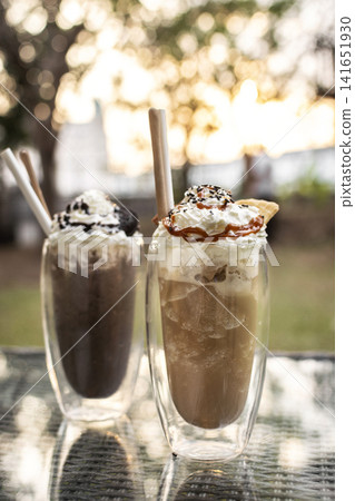 Chocolate and Coffee ice cream sundae milkshake drinks on outdoor cafe table Chocolate and Coffee ice cream sundae milkshake drinks on outdoor cafe table 141651930