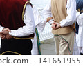 Serbian folk dance group marching in the street 141651955