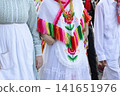 Mexican folk dancers marching in the street 141651976