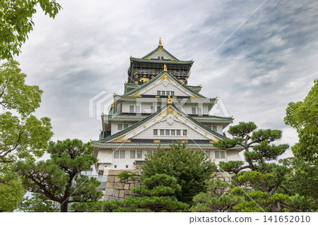 Osaka castle main keep standing among green trees Osaka castle main keep standing among green trees 141652010