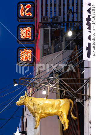 Golden bull statue attracting tourists in dotonbori at night Osaka 141652014