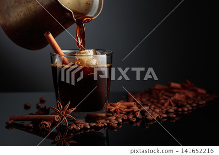 Coffee is poured into a glass with ice. 141652216